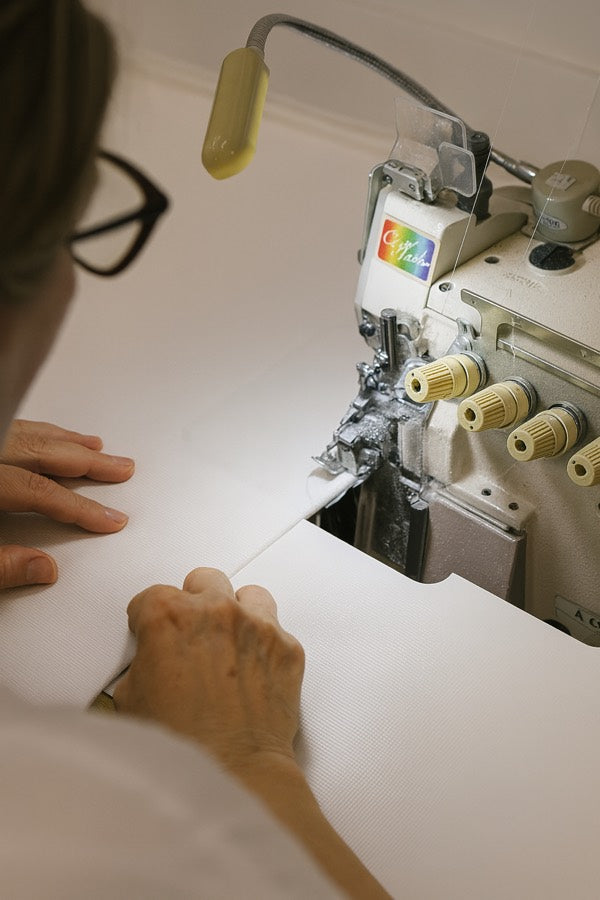 Näherin an der Overlock-Maschine in der Mediair Manufaktur